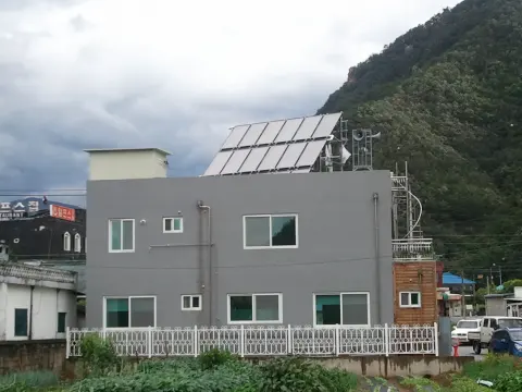 옥상에 집열기가 있는 회색 건물