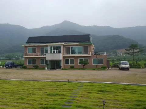 산을 배경으로 한 2층 건물 지붕 집열기