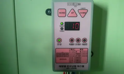 녹색 벽에 붙은 분홍 제어기